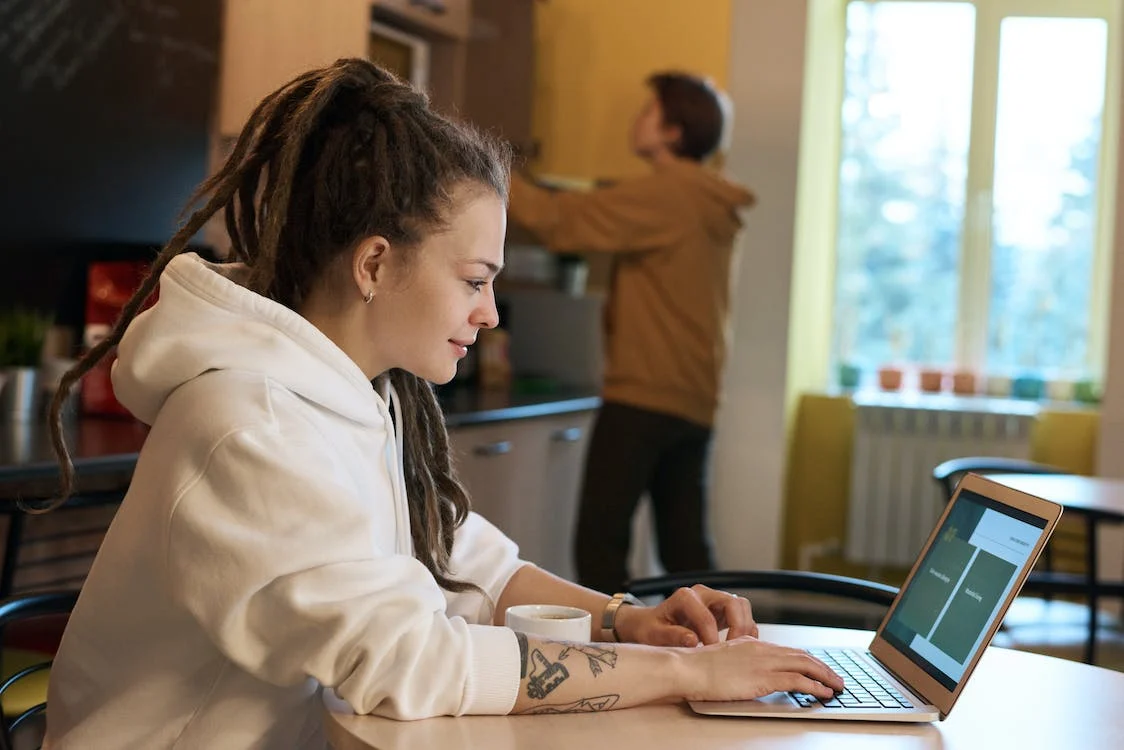 A self-employed woman focused on her laptop, looking at her self-employment tax rate