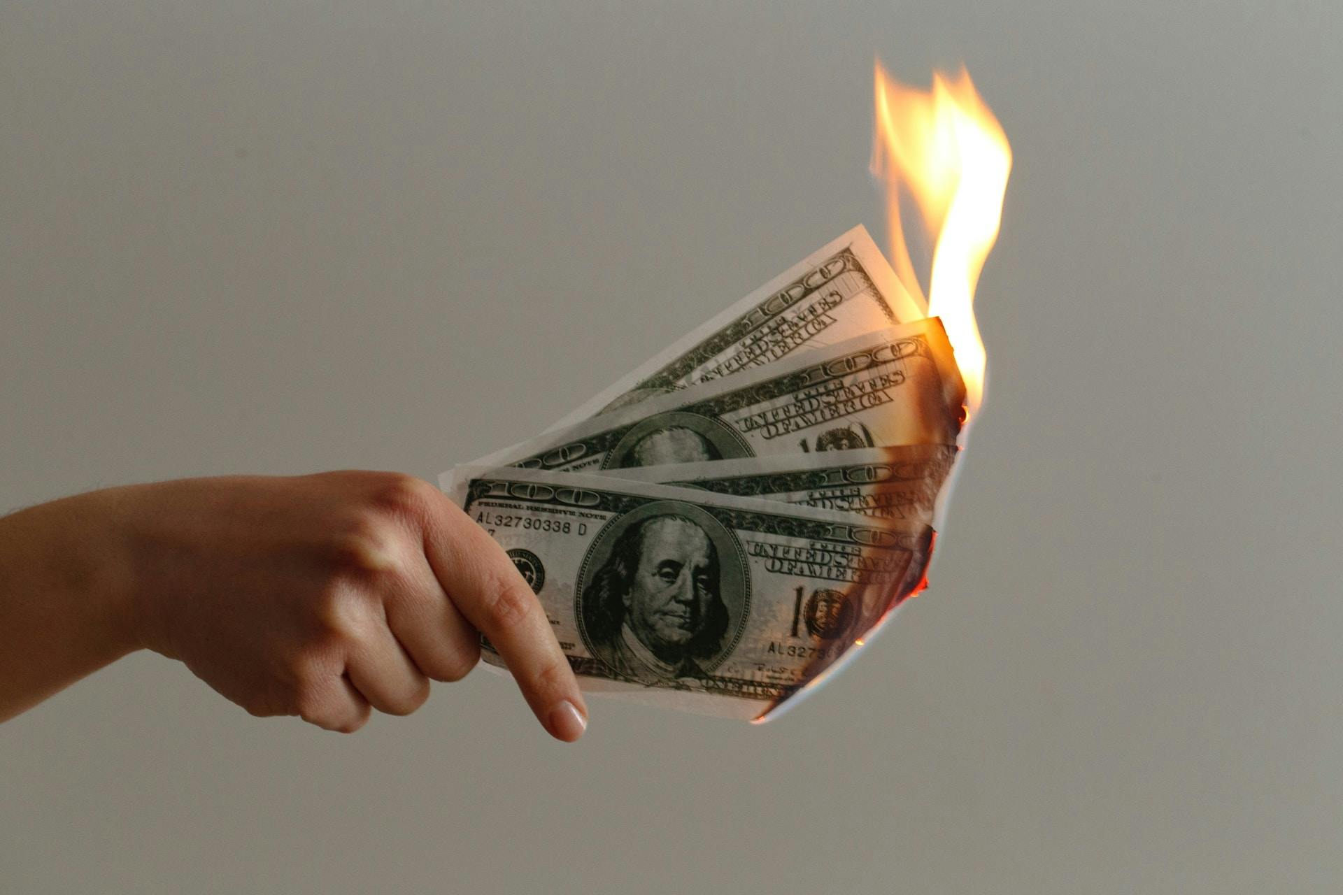  A hand holding burning cash