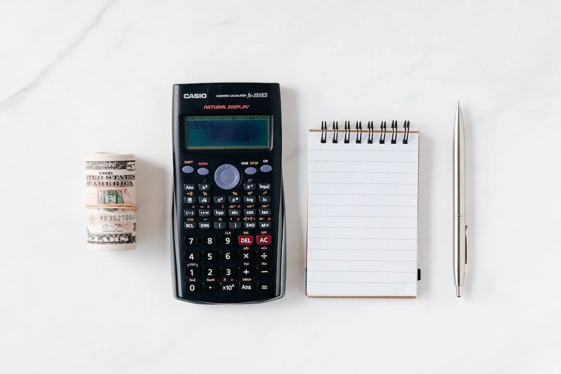Cash, calculator, paper pad, and a pen