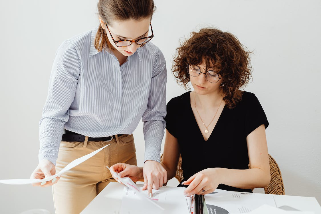 Two employees examining payroll journal entry