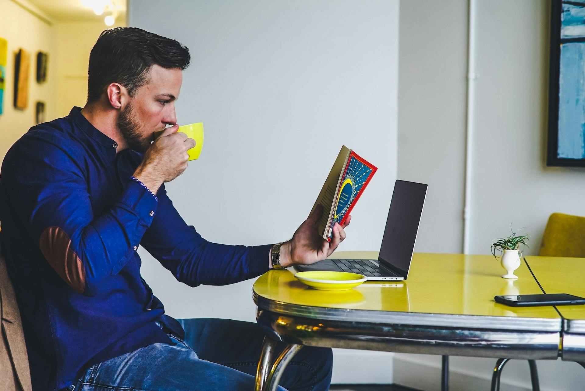 A man enjoying a book while sipping coffee